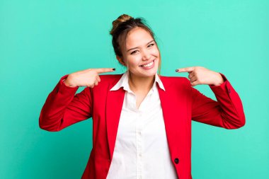 Hispanik güzel kadın kendi gülüşünü işaret ederek kendine güvenerek gülümsüyor. iş kavramı