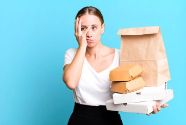 caucasian pretty woman feeling bored, frustrated and sleepy after a tiresome. with fast food packages. delivery concept