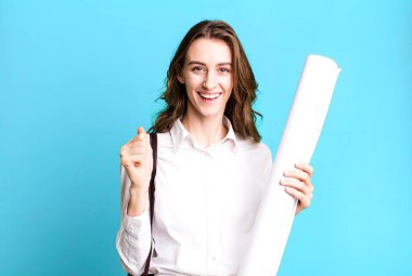 young pretty woman feeling shocked,laughing and celebrating success. architect concept