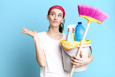 young pretty woman feeling puzzled and confused and doubting. housekeeper concept