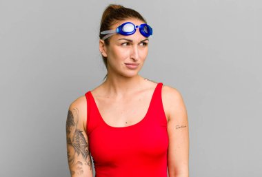 Genç, güzel bir kadın üzgün, üzgün ya da kızgın hissediyor ve yan tarafa bakıyor. yüzücü kavramı