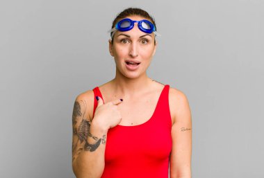 Şok olmuş ve ağzı açık, kendini gösteren genç ve güzel bir kadın. yüzücü kavramı