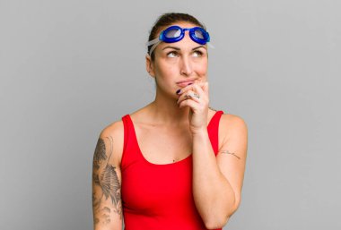 Genç, güzel bir kadın düşünüyor, kuşkulu ve şaşkın hissediyor. yüzücü kavramı