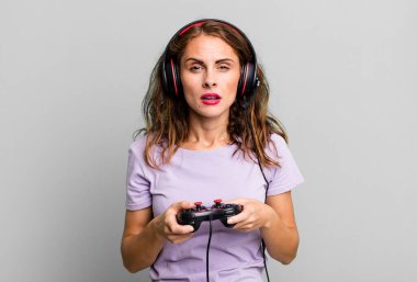 hispanic pretty young woman playing with headphones and a control. gamer concept