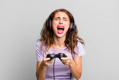 hispanic pretty young woman playing with headphones and a control. gamer concept