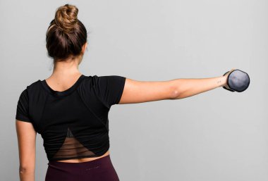 hispanic pretty young woman lifting a dumbbell. fitness concept