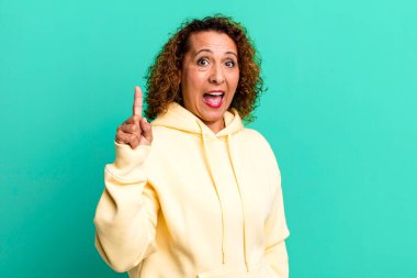 Orta yaşlı İspanyol bir kadın bir fikri fark ettikten sonra mutlu ve heyecanlı bir dahi gibi hissediyor, neşeli bir şekilde parmağını kaldırıyor, eureka!