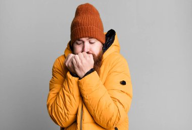 Uzun sakallı, kızıl saçlı, şapkalı ve ceketli havalı bir adam. Soğuk ve kış kavramı