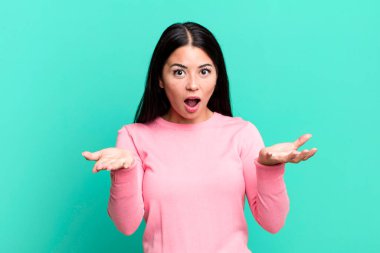 Güzel Latin bir kadın son derece şaşırmış, şaşırmış, endişeli ve paniklemiş, stresli ve dehşete kapılmış görünüyor.