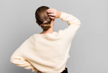 Kafası karışık, kafası karışık, eli kalçasında, dikiz aynasıyla bir çözüm düşünüyor.