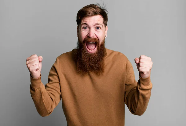 長い髭と赤い髪の男はショックを受け笑いそして成功を祝う — ストック写真