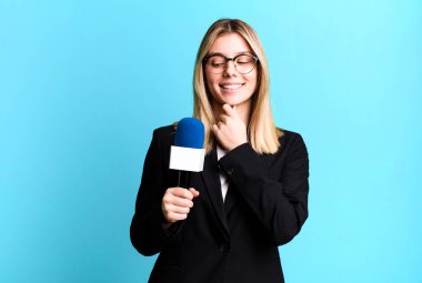young pretty woman smiling with a happy, confident expression with hand on chin. presenter or journalist concept