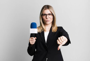 Genç ve güzel bir kadın kendini kötü hissediyor, baş parmağını kaldırıyor. sunucu veya gazeteci kavramı