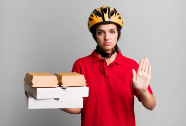 young pretty woman looking serious showing open palm making stop gesture. pizza delivery concept