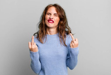 Genç, güzel bir kadın kışkırtıcı, agresif ve müstehcen hissediyor. İsyankar bir tavırla orta parmağını hareket ettiriyor.