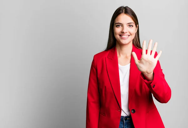 stock image young pretty woman smiling and looking friendly, showing number five. businesswoman concept