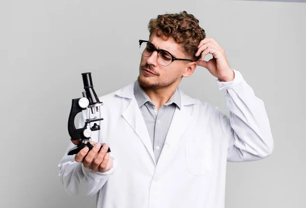 Kafası Karışmış Kafası Karışmış Kaşınan Genç Beyaz Bir Adam Mikroskop — Stok fotoğraf
