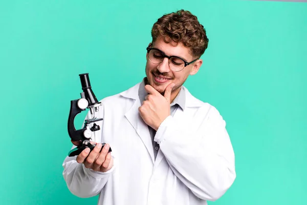 코카서스 남자는 행복하고 자신감 표정으로 있었다 현미경 개념을 실험실 학생들에게 — 스톡 사진