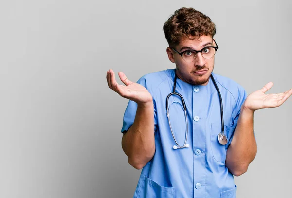 若い大人の白人男性は困惑し混乱し疑問を感じています 看護師の概念 — ストック写真