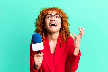 Kızıl saçlı güzel kadın umutsuz, sinirli ve stresli görünüyor. gazeteci ve sunucu kavramı