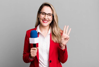 Gülümsüyor ve arkadaş canlısı görünüyor, üç numarayı gösteriyor. gazeteci veya sunucu kavramı