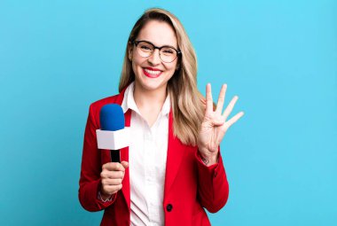 Gülümsüyor ve dost canlısı görünüyor, dört numarayı gösteriyor. gazeteci veya sunucu kavramı