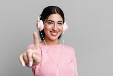 Gururla gülümseyen ve kendinden emin bir numara olan. kulaklıkla müzik dinlemek