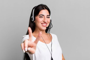 smiling and looking happy, gesturing victory or peace. telemarketer concept