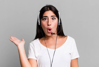 looking surprised and shocked, with jaw dropped holding an object. telemarketer concept