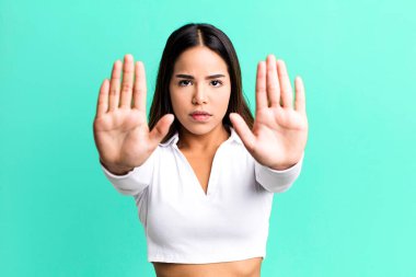 İspanyol güzel kadın ciddi, mutsuz, kızgın ve hoşnutsuz görünüyor. Girmeyi yasaklıyor ya da iki avucunun içinde de dur diyor.