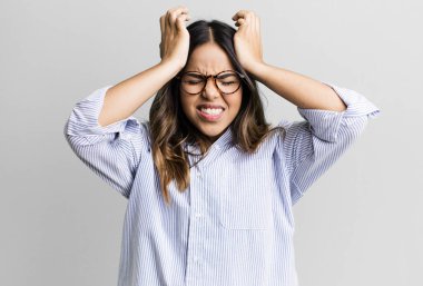 İspanyol güzel kadın stresli ve endişeli, depresif ve hayal kırıklığına uğramış hissediyor, iki elini de başa kaldırıyor.