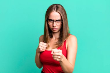 Kendinden emin, sinirli, güçlü ve agresif görünüyor. Yumrukları boks pozisyonunda dövüşmeye hazır.