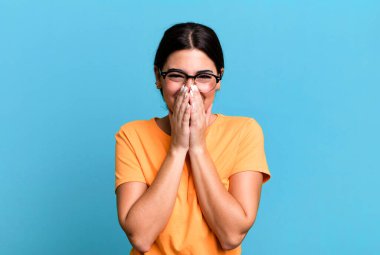 Mutlu, neşeli, şanslı ve şaşkın görünüyor iki eliyle ağzını kapatıyor.