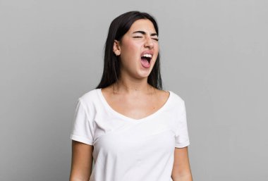 Öfkeyle bağırıyor, agresif bağırıyor, stresli ve sinirli görünüyor.