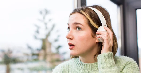 ヘッドフォンで音楽を聴いてる若い女性 家のインテリアデザイン — ストック写真