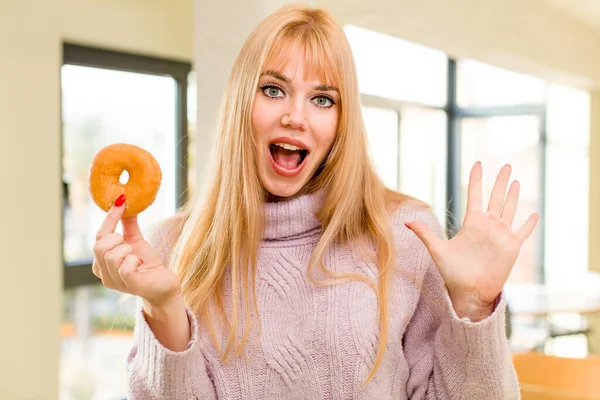 一个有甜甜圈的年轻漂亮的女人 家庭内部不健康饮食概念 — 图库照片