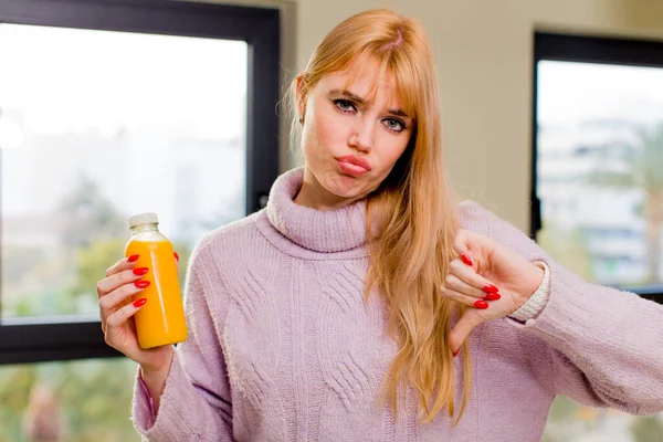 家の中でオレンジジュースを飲んでいる若い可愛い女性は — ストック写真