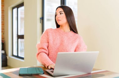 pretty young woman with a laptop on a desk  at home