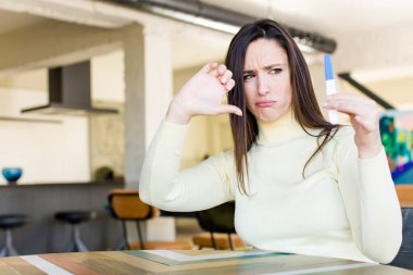 young adult pretty woman with a Pregnancy test result