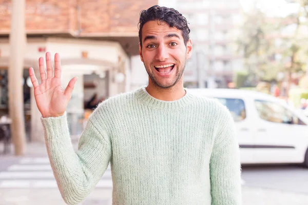 Jonge Spaanse Man Glimlacht Vrolijk Vrolijk Zwaait Met Hand Verwelkomt — Stockfoto
