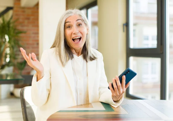漂亮的老年妇女对使用智能手机的令人难以置信的事情感到快乐和惊讶 — 图库照片