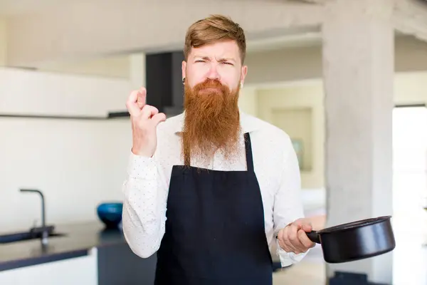 赤い髪の男が指を渡りキッチンで幸運を願ってる シェフのコンセプト — ストック写真