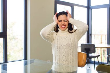 pretty caucasian woman feeling stressed, worried, anxious or scared, with hands on head, panicking at mistake