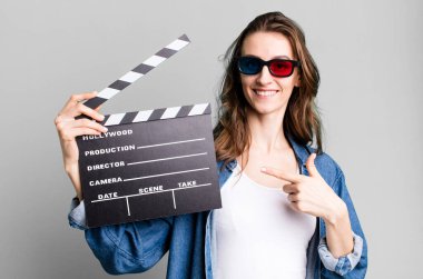 Genç ve güzel bir kadın, elinde alkışlı bir sinema tahtası tutuyor.