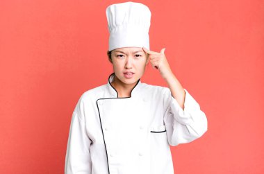 Güzel Asyalı kadın kafası karışık ve şaşkın hissediyor, senin deli olduğunu gösteriyor. restoran şefi konsepti