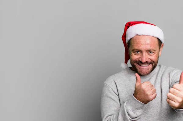 中年の男は誇りを感じ 親指を上げて積極的に笑顔 クリスマスのコンセプト — ストック写真