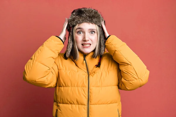 若い女性はストレスを感じ不安や恐怖を感じ手を頭にして 寒さとコートのコンセプト — ストック写真