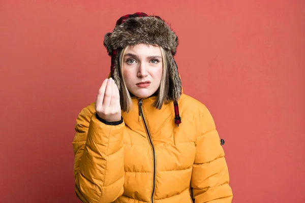 若い可愛い女性が金を払うように言ってる 寒さとコートのコンセプト — ストック写真