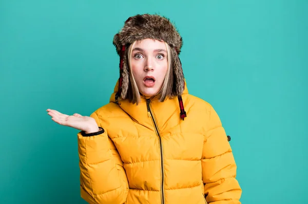 若い可愛い女が驚いてショックを受け顎が物を持って落下した 寒さとコートのコンセプト — ストック写真