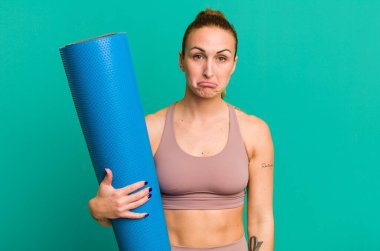 young pretty woman feeling sad and whiney with an unhappy look and crying. fitness and yoga concept